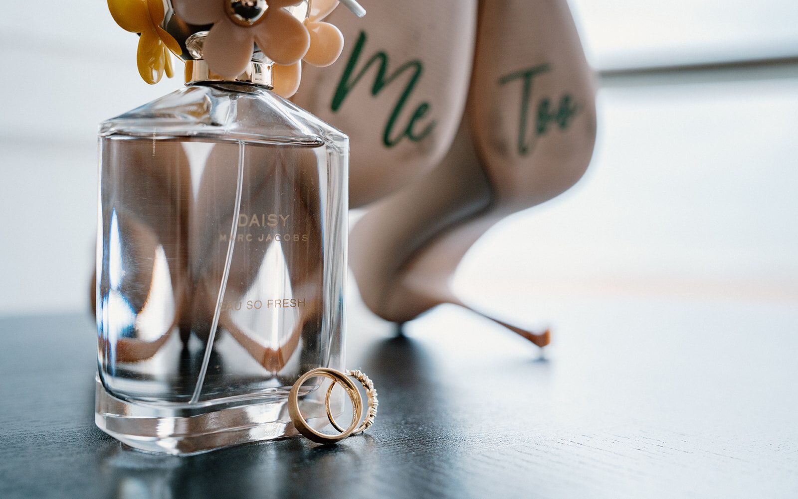 Nature morte du parfum, des alliances et de l'inscription Me Too sur la jambe