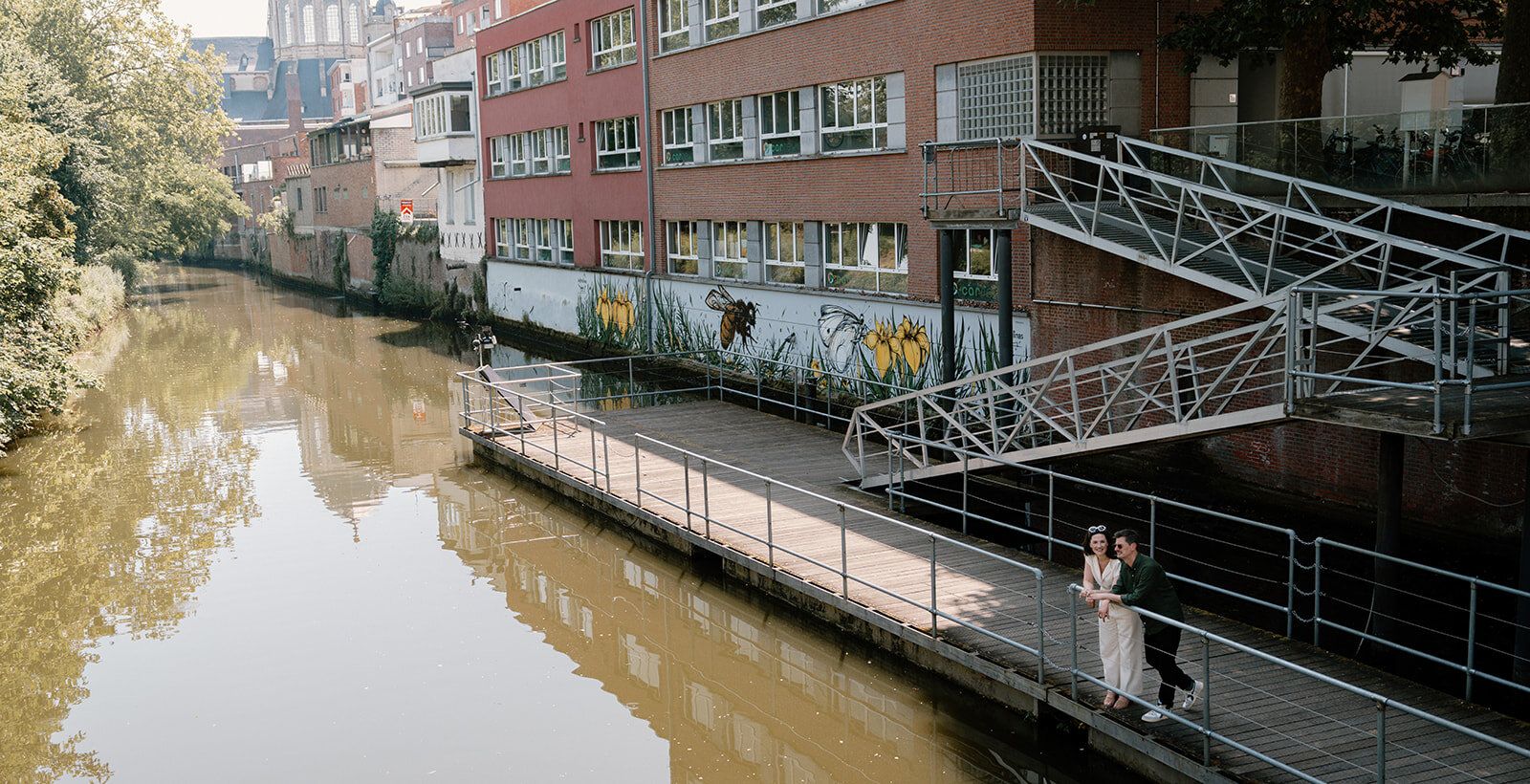 Le couple debout sur une passerelle métallique au-dessus d'un canal
